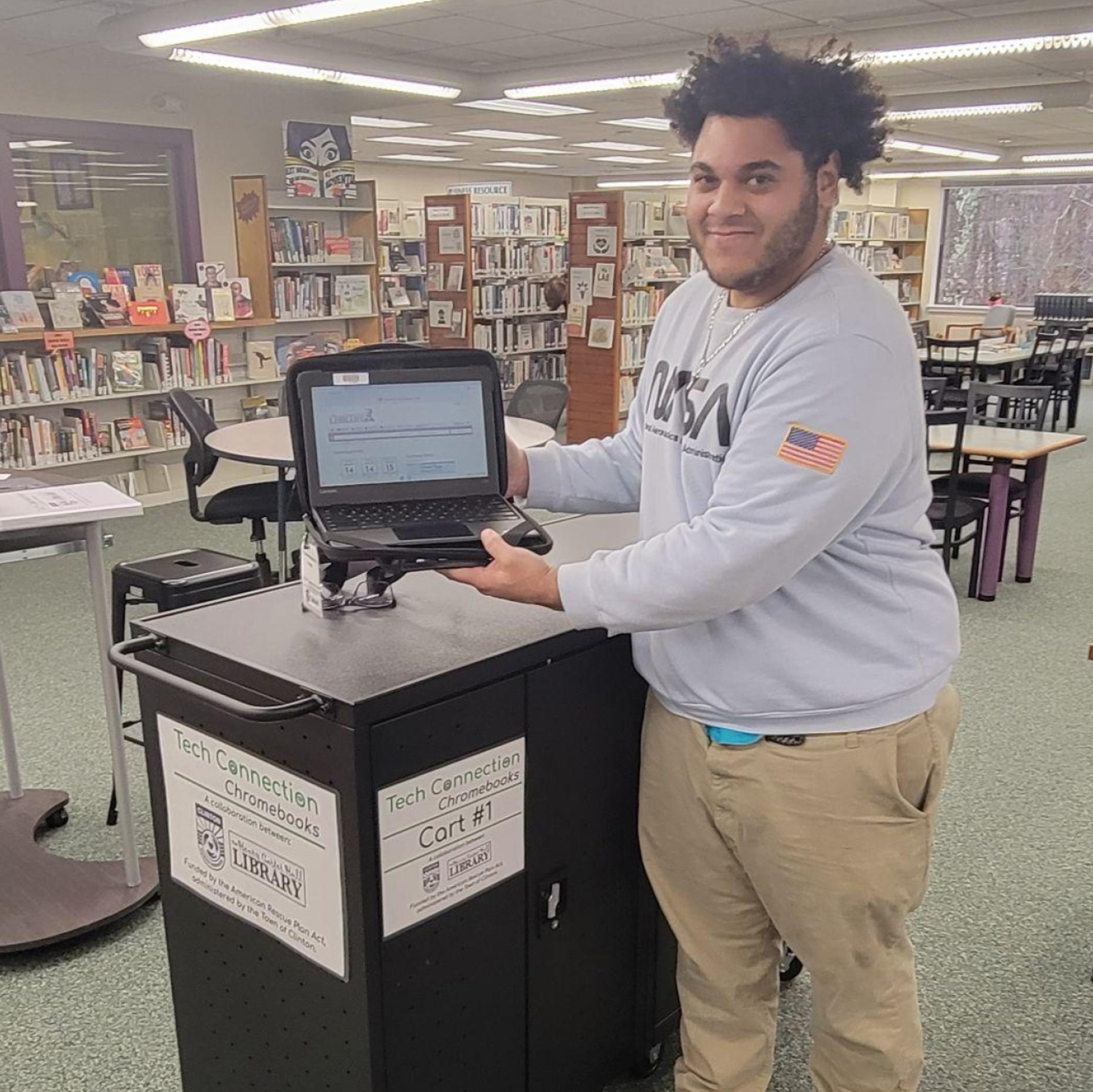 Tech Guide Matthew Capece with Chromebook at HCH Library